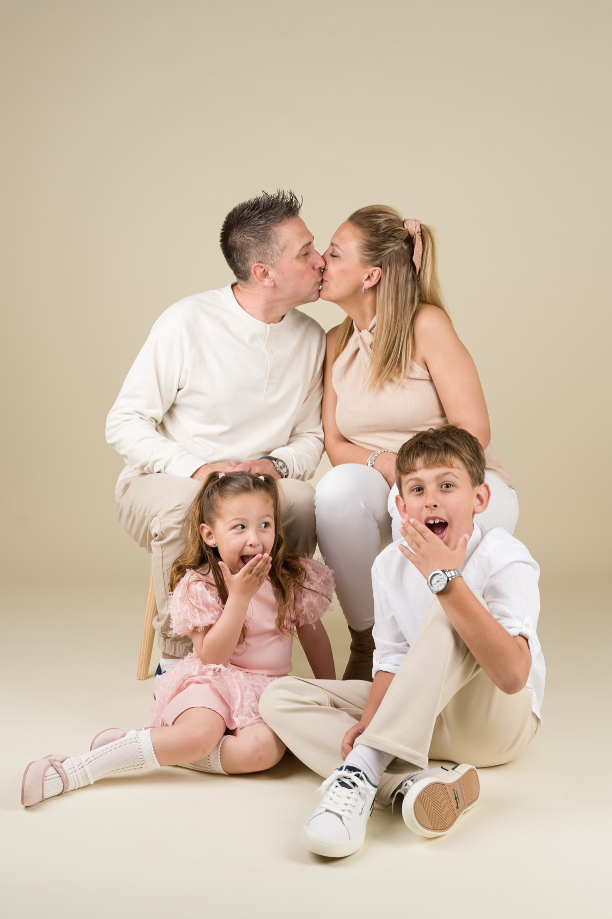 Familia reunida en un retrato de estudio luminoso.
