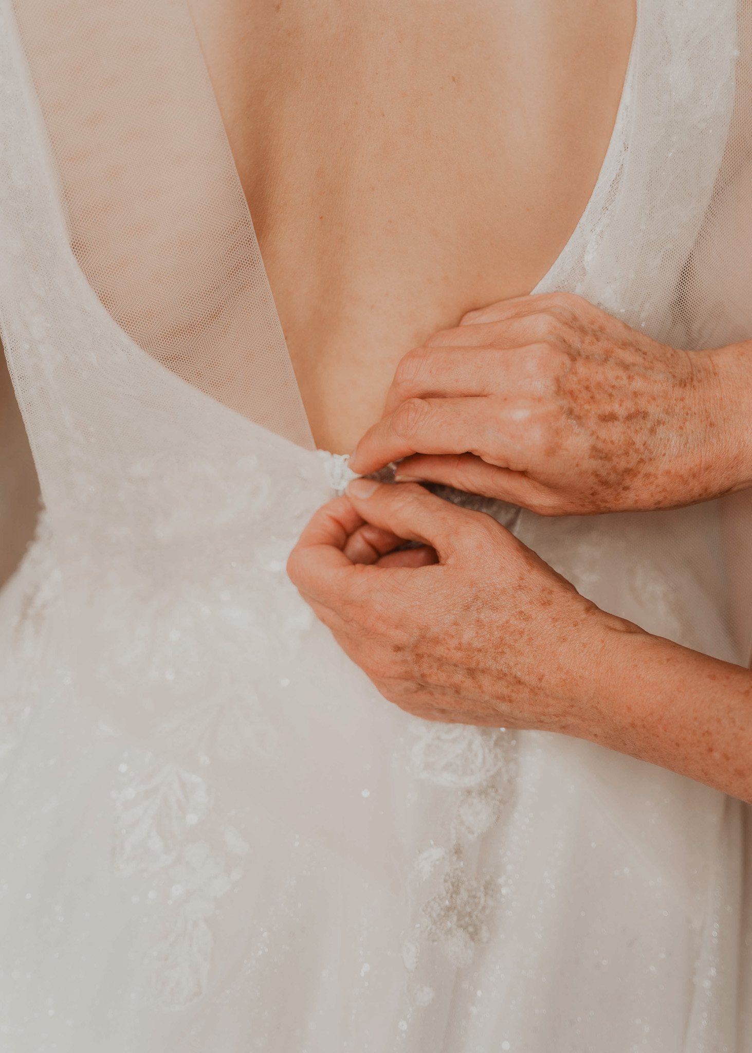 Deux proches tiennent les mains de la mariée.