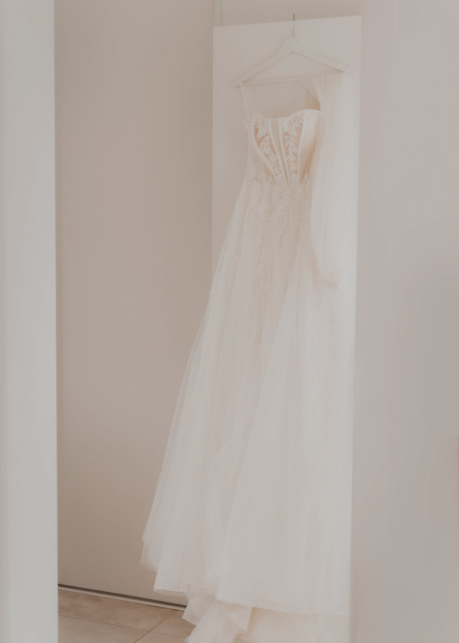 La silhouette d'une mariée derrière un voile clair.