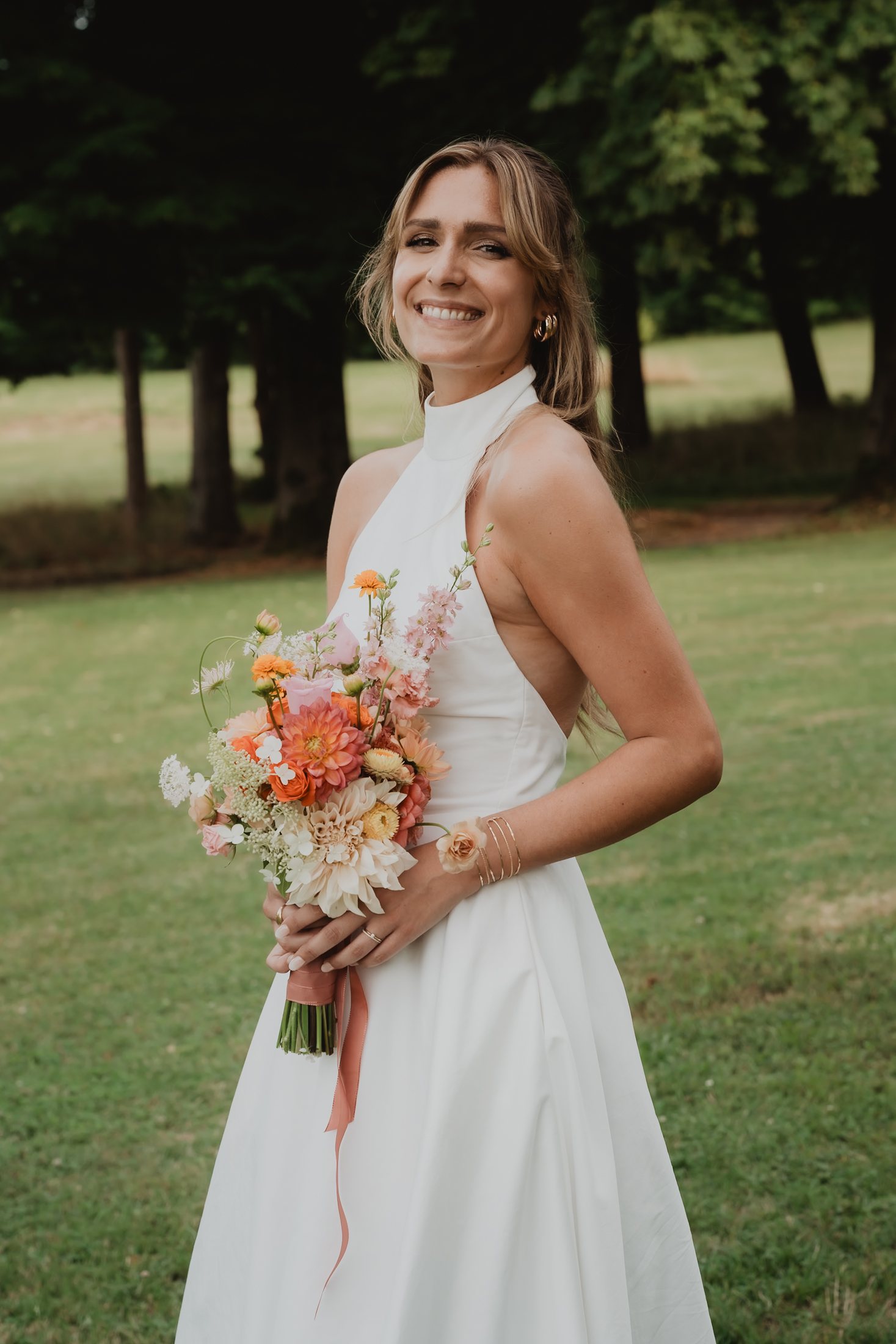 Une mariée tient un bouquet de fleurs sauvages.