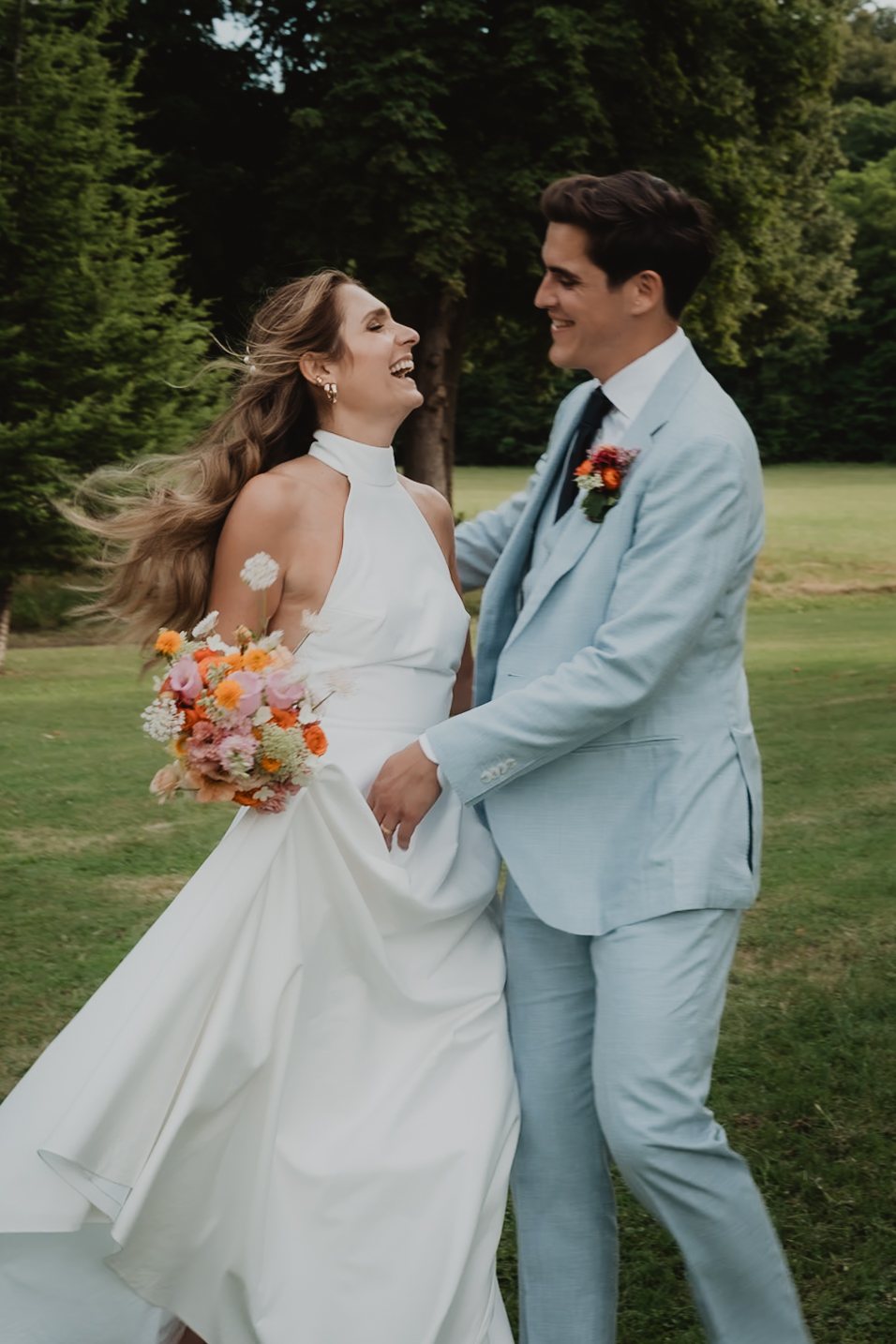 Un couple pose enlacé avec un costume bleu clair.