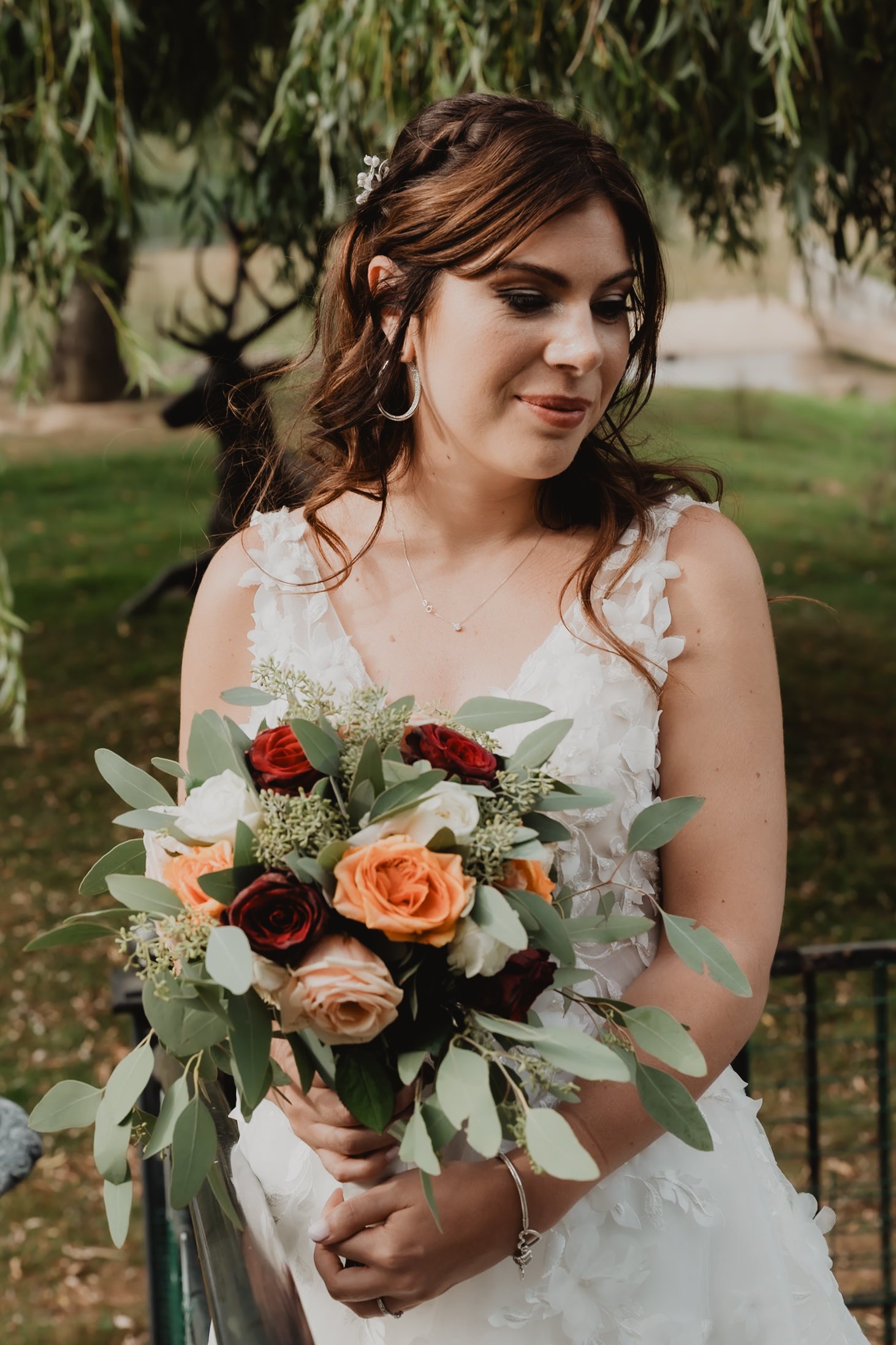 Une mariée tient un bouquet de fleurs corail.
