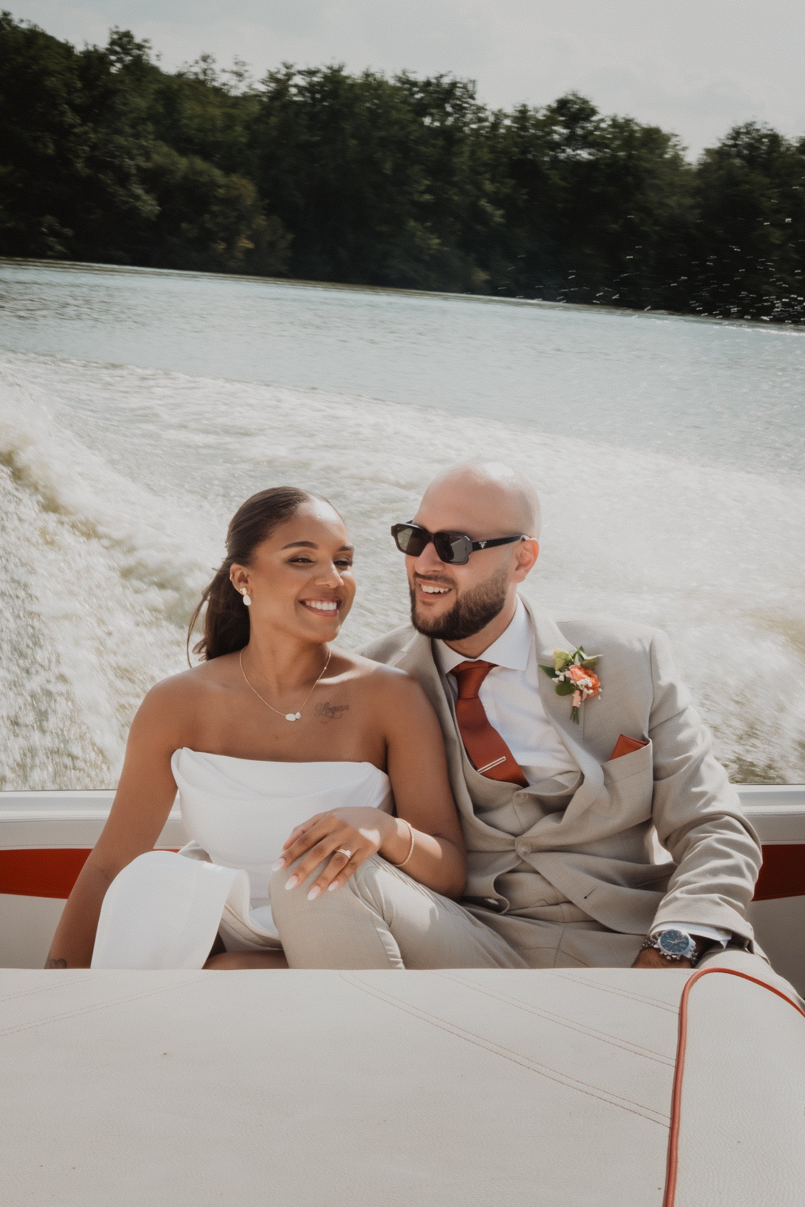 Un couple sourit pendant une séance après le mariage sur un bateau.