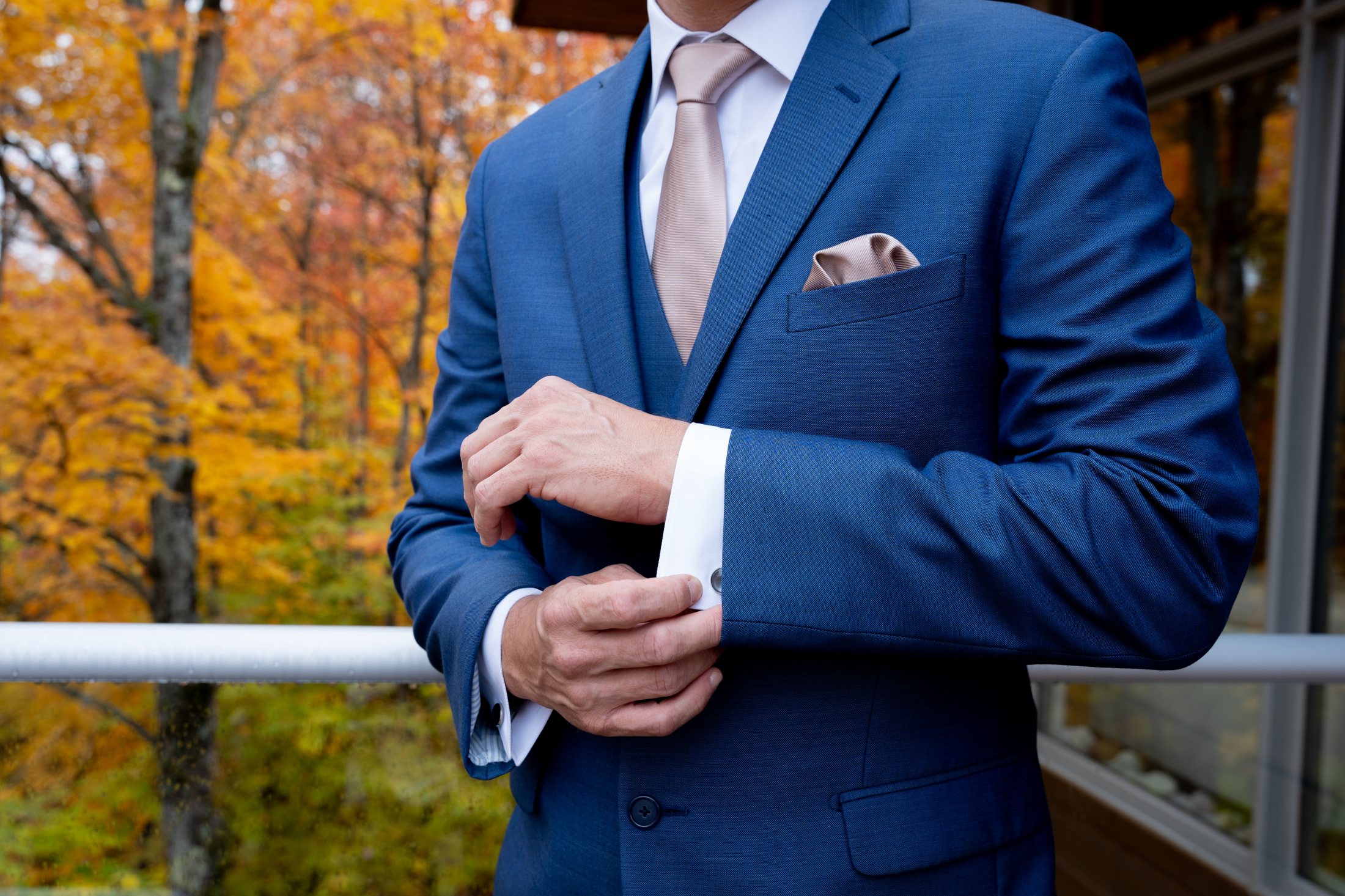 Retrato elegante con traje azul, encuadrado en las manos y la chaqueta.