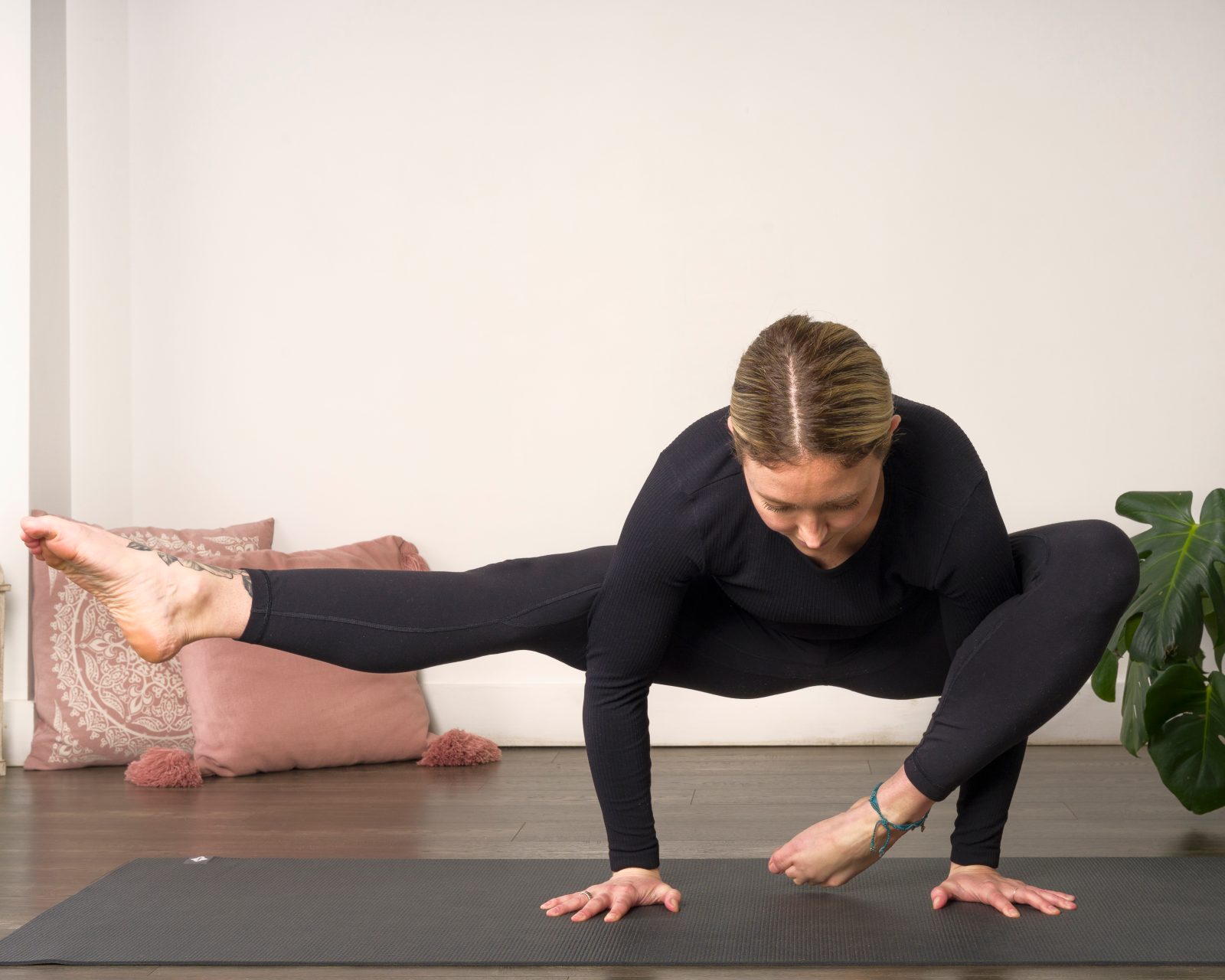 Demostración de una postura de yoga en equilibrio sobre los brazos.