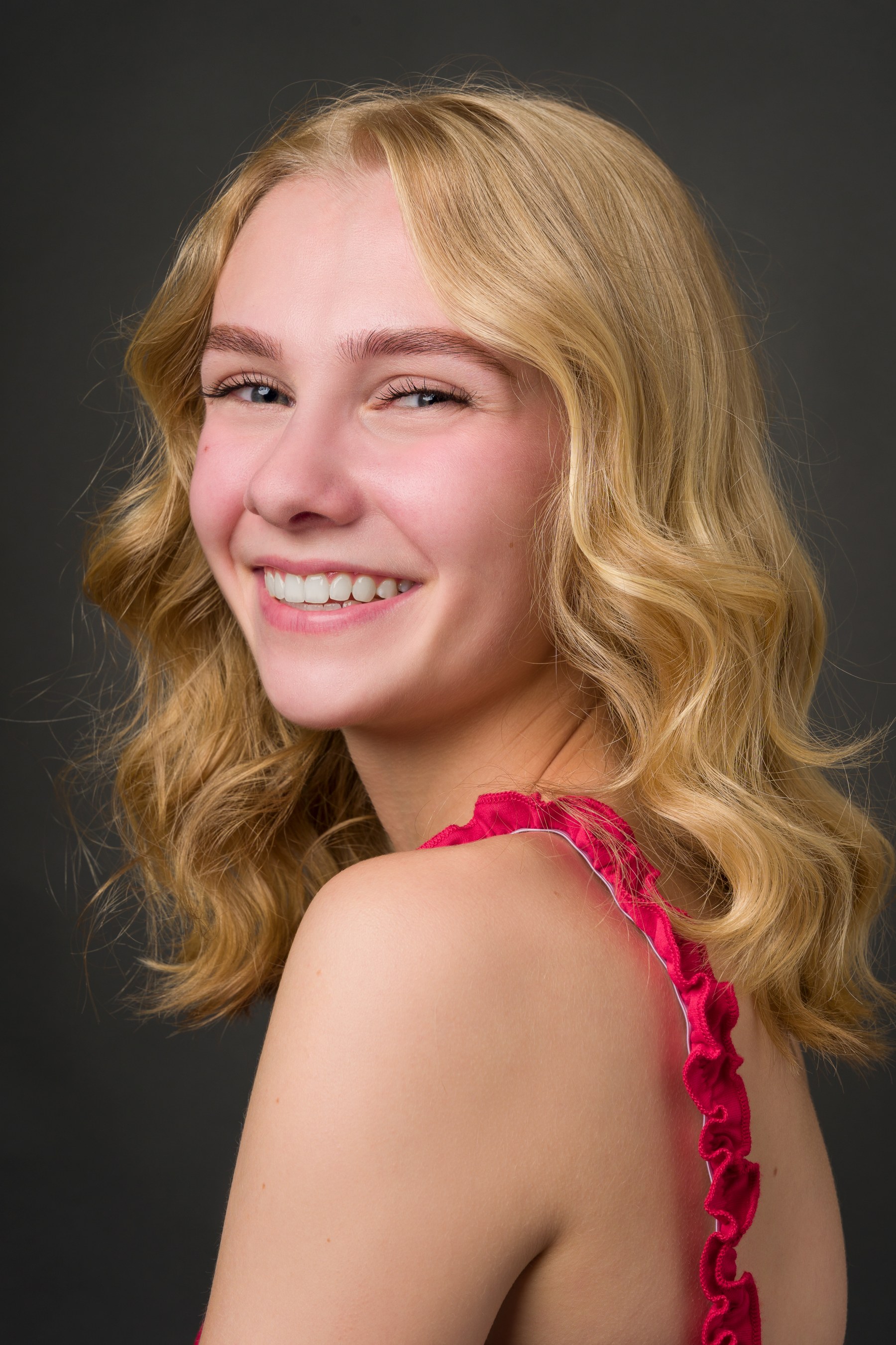 Retrato casting en estudio de una joven actriz rubia sonriente.