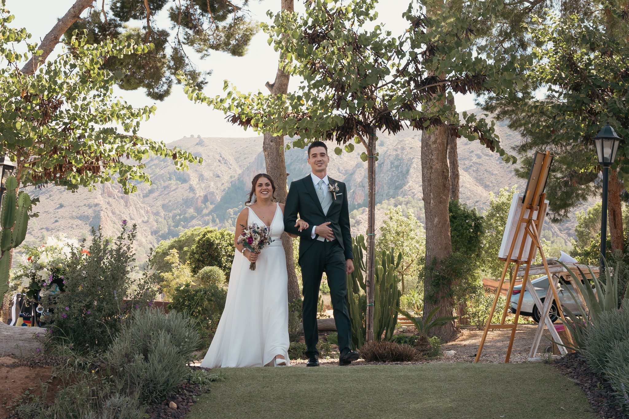 Couple de mariés devant un paysage de montagne.